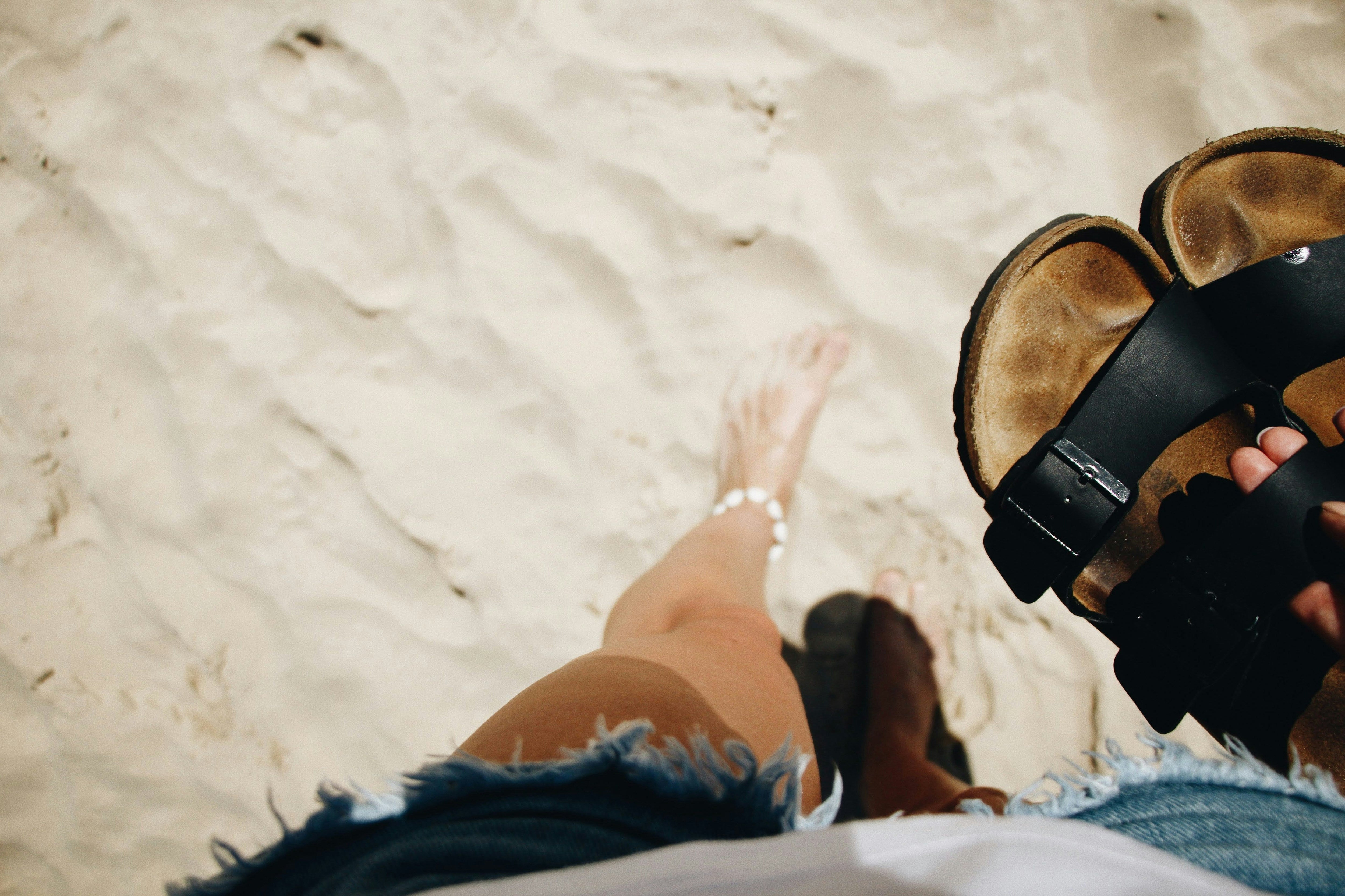 Person walking along the beach with repaired Birkenstocks by Shanes Shoe repairs